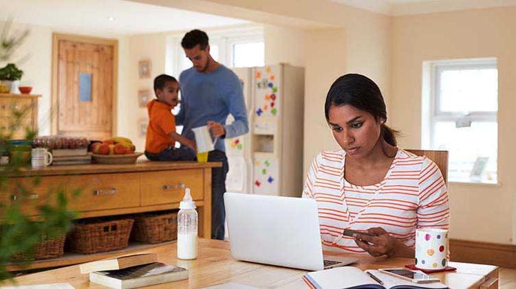 Woman at her laptop reviewing social media settings to ensure her personal information is protected.